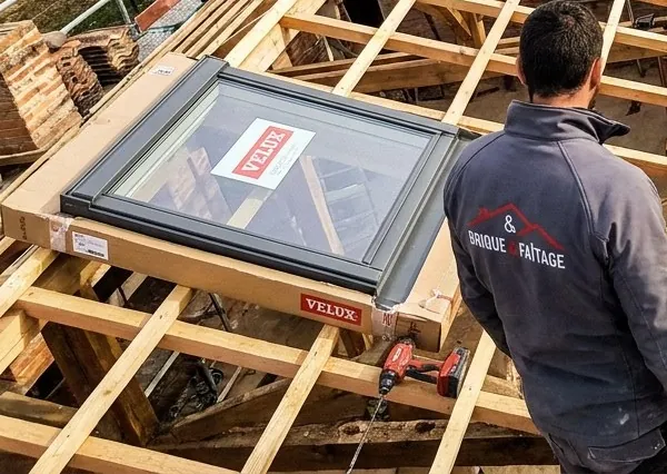 Fenêtre de toit Velux posée sur des liteaux neufs pendant une rénovation de toiture, couvreur Brique & Faîtage